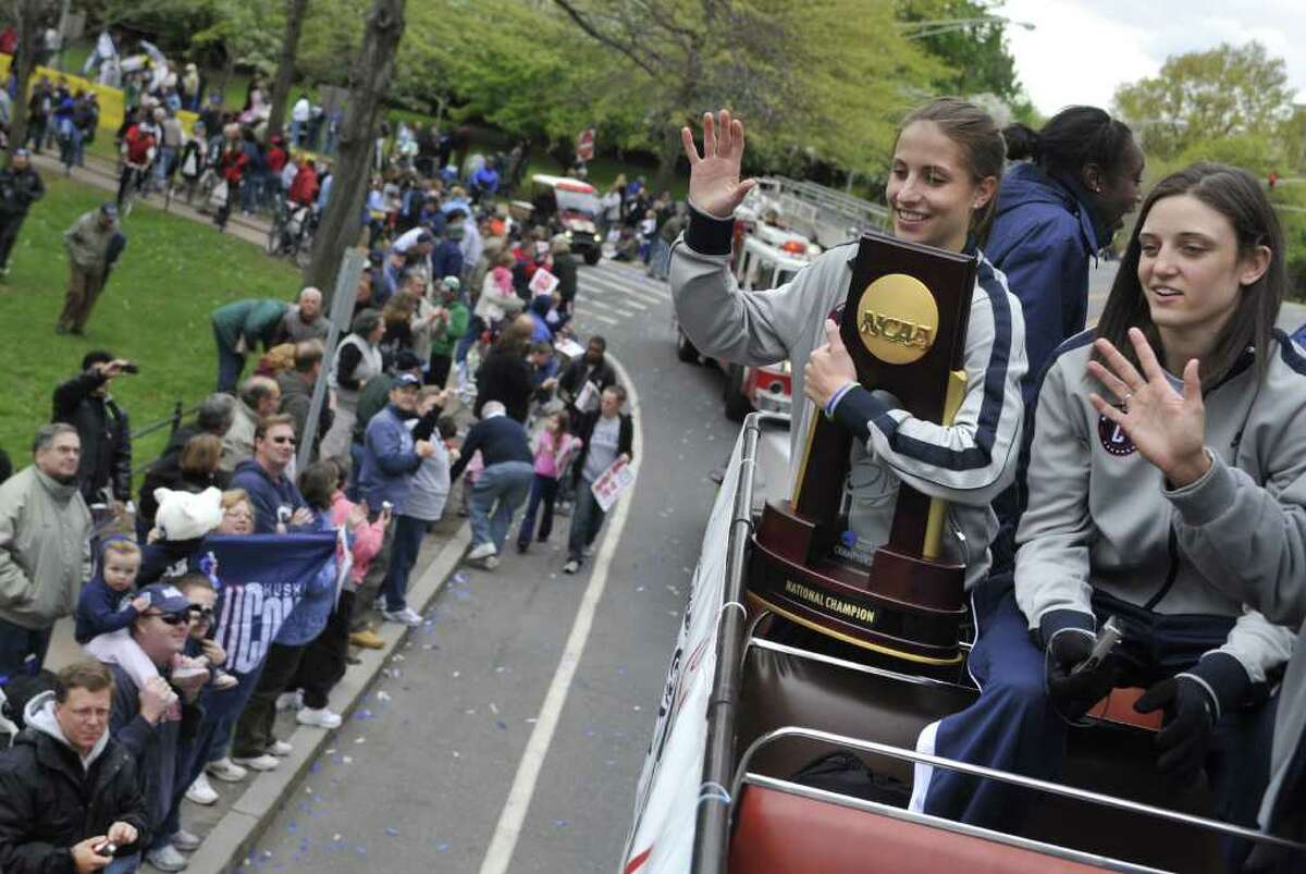 Connecticut's Caroline Doty, holding trophy, and Kelly Faris wave to fans during a parade Sunday, April 18, 2010, in Hartford, Conn., celebrating the team's victory in the NCAA college tournament. (AP Photo/Jessica Hill)