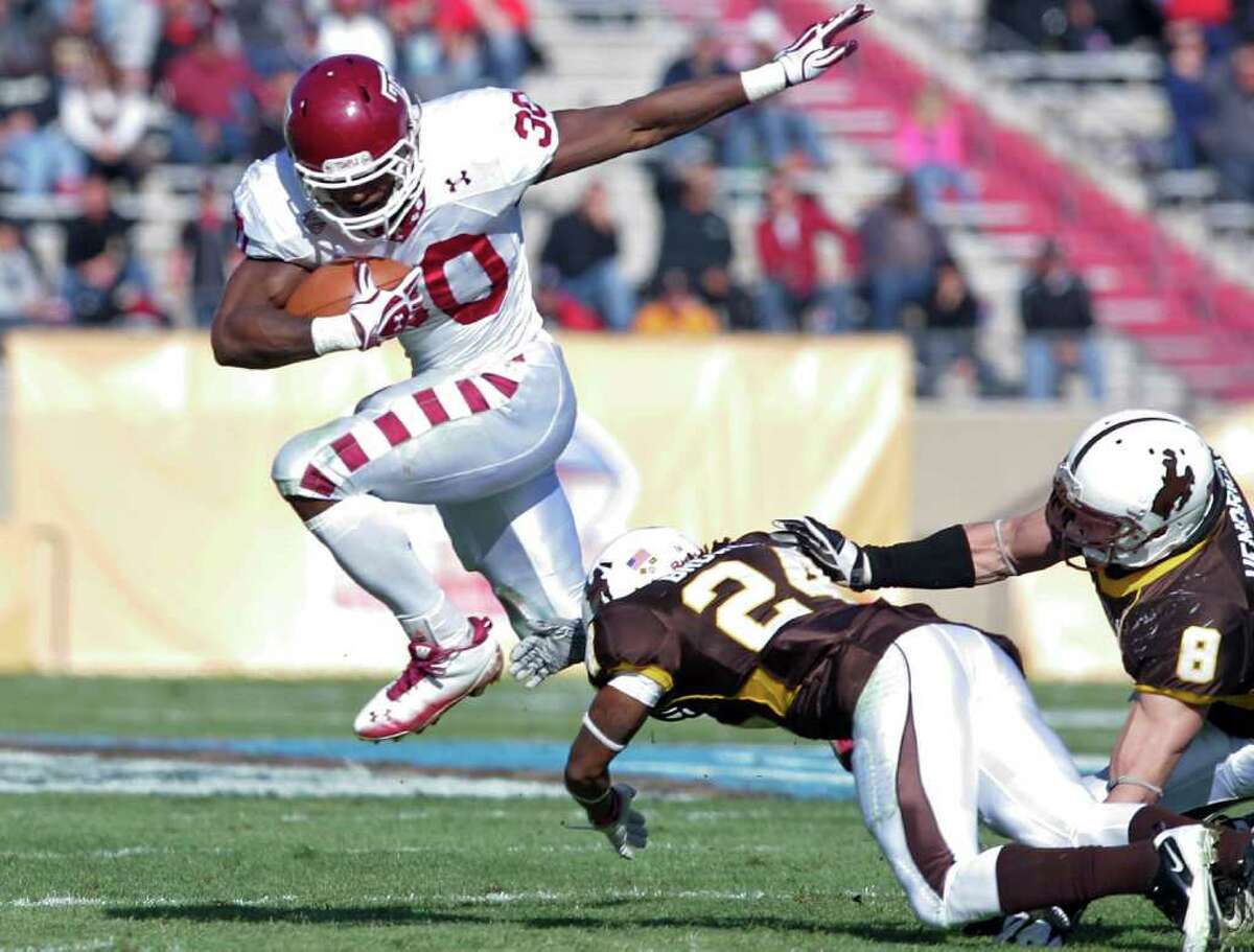 Temple running back Bernard Pierce (30) leaps over Wyoming defensive back Kenny Browder (24) and linebacker Brian Hendricks (8) in the second quarter of the New Mexico Bowl NCAA college football game in Albuquerque, N.M., Saturday, Dec. 17, 2011. (AP Photo/Jake Schoellkopf)