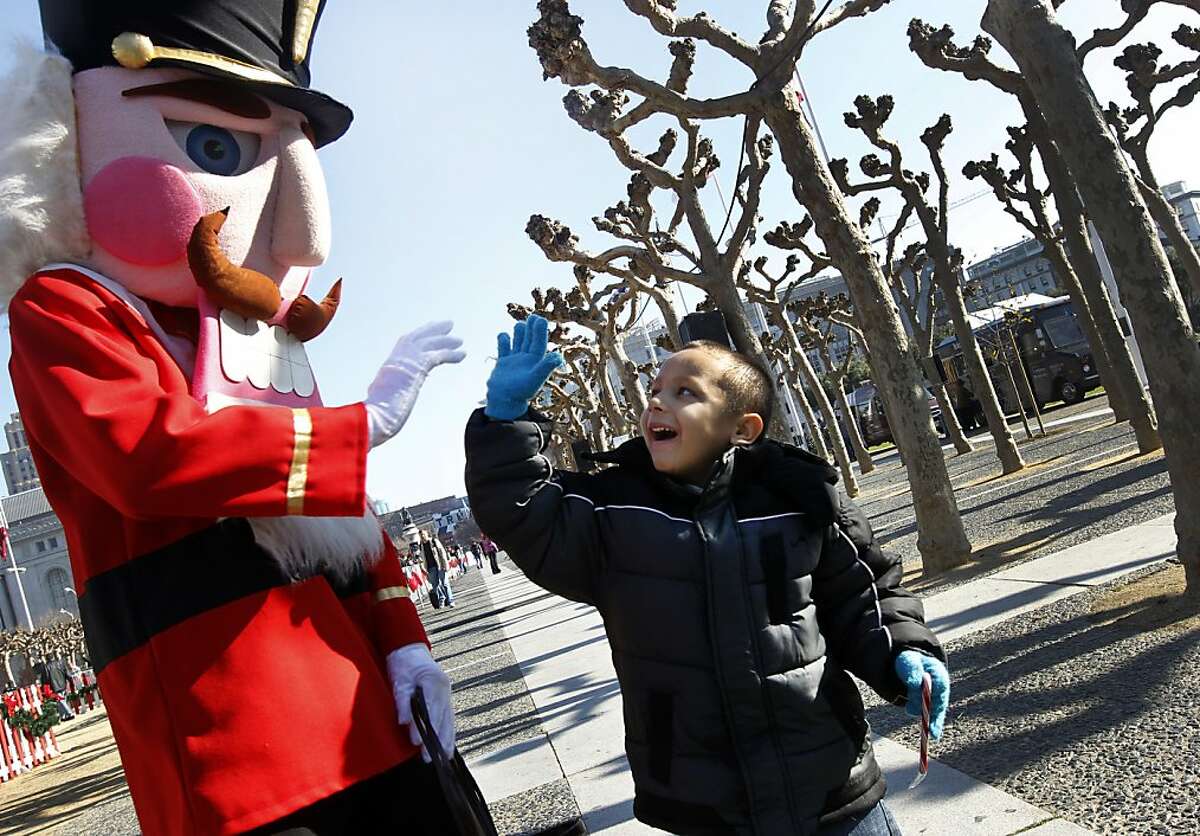 Christian Taylor, 5, high-fives a nutcracker (Matthew Cogley), who was handing out candy canes to children at a holiday snow park at Civic Center Plaza in San Francisco, Calif. on Saturday, Dec. 17, 2011.