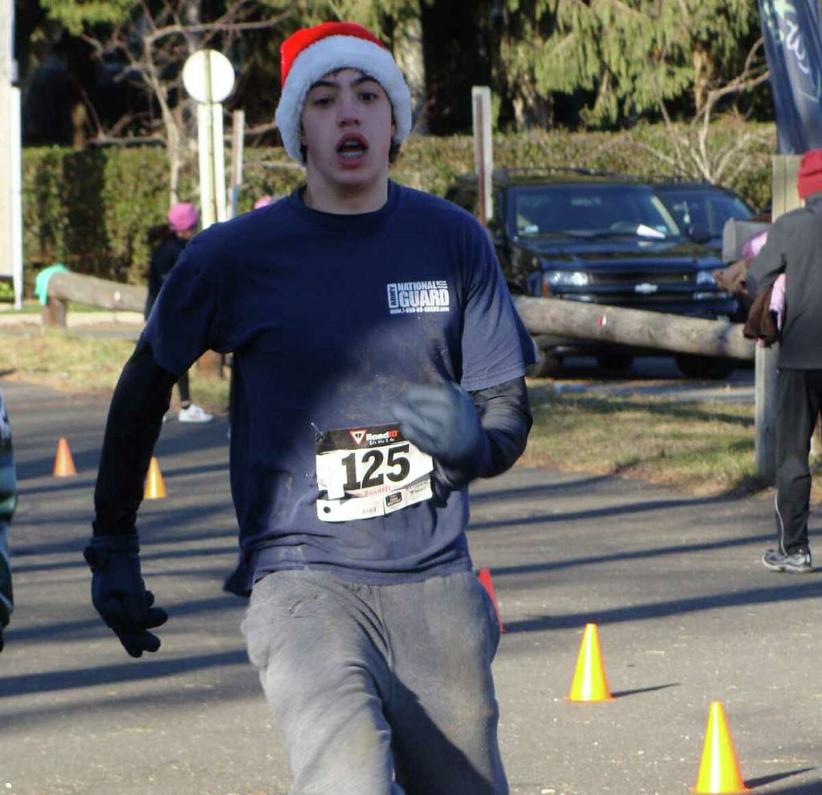 Mike Dana, 16, crosses the finish line in Sunday's 5K Holiday Run for Toys in Fairfield with a time of 24:31 wearing a Santa cap. Dana donated a 10-piece set of board games as part of his race entry fee, "Because I just wanted to help out the kids," he said.