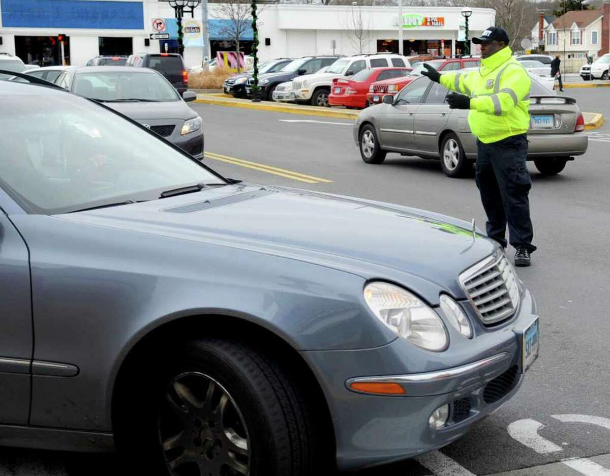 Everol Campbell of Integrated Security directs traffic at the Ridgeway Shopping Center in Stamford on Tuesday, December 20, 2011.