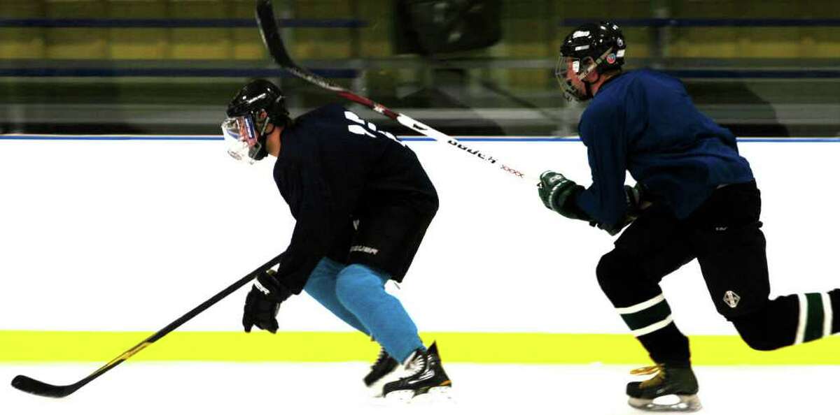 SPECTRUM/Joel Steele, right, of New Milford High School ice hockey attempts to track down teammate Chad Fasig during a pre-season drill at Canterbury School. December 2011