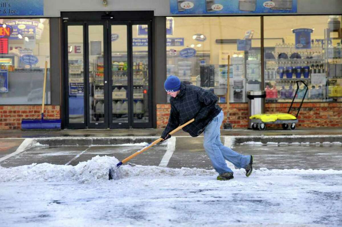 Kevin Wesson shovels a path for customers at the Water Still, on Tuesday morning Dec. 20, 2011 after an overnight storm covered Amarillo with about an inch of ice and snow. Several major thoroughfares were closed after the storm clipped the far northwest part of the state the day before the official start of winter. (AP Photo/Amarillo Globe-News, Michael Schumacher) MANDATORY CREDIT; MAGS OUT; TV OUT; INTERNET OUT; AP MEMBERS ONLY
