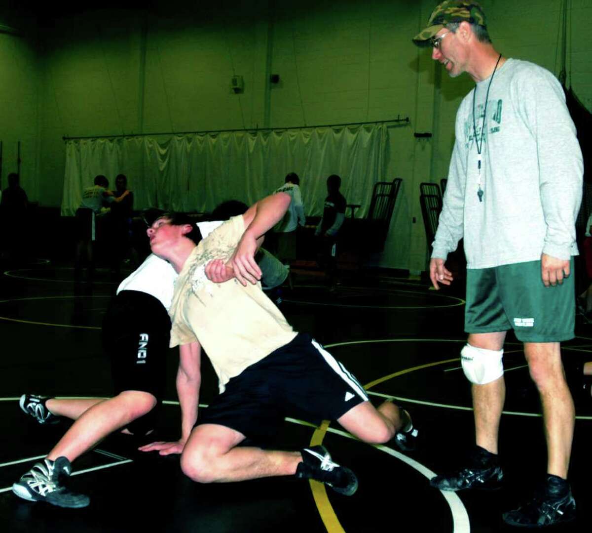 SPECTRUM/Coach Chris Piel keeps a close watch on his grapplers' technique in pre-season as New Milford High School wrestling preps for the 2011-12 campaign. December 2011