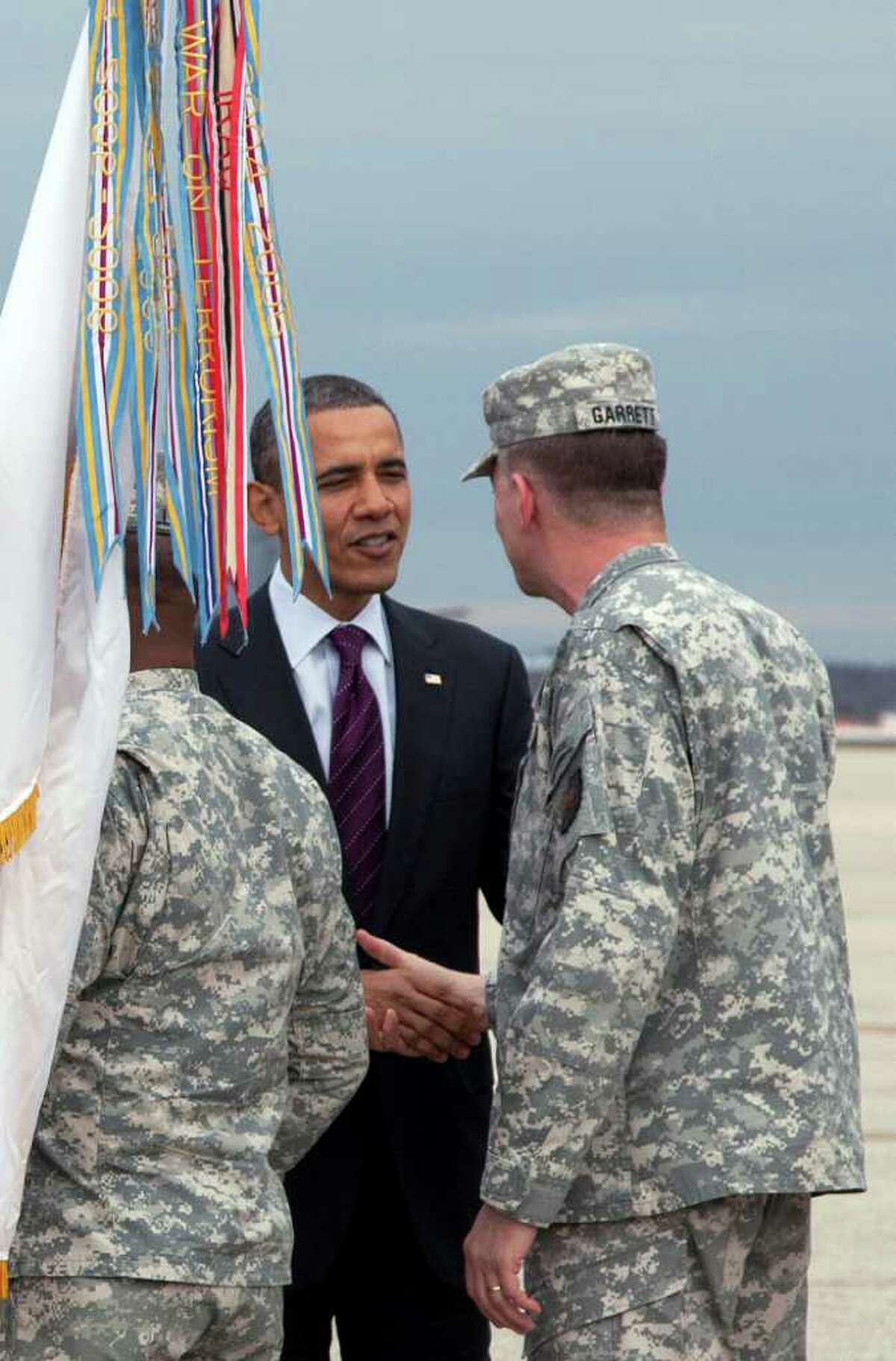 CAROLYN KASTER: ASSOCIATED PRESS WELCOME HOME: President Barack Obama greets troops Tuesday as they step off a plane at Andrews Air Force Base, Md., during a ceremony marking the return of the United States Forces' Iraq Colors, visible in foreground at left.