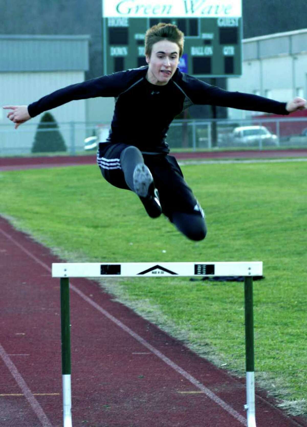 SPECTRUM/Dennis Rafferty of the Green Wave easily soars over a hurdle as the New Milford High School boys' and girls' track teams work in pre-season through the process of just who will be competing in which events this winter. December 2011
