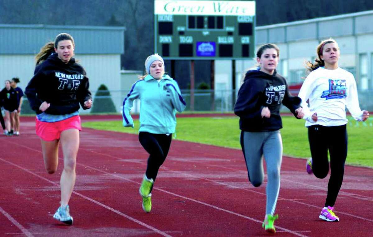 SPECTRUM/Working into competitive condition with sprints on the track are New Milford High School girls' indoor track athletes, from left to right, Lindsay Guptill, Claire Brofford, Meghan Dietter and Evangelia Lambropoulos. December 2011