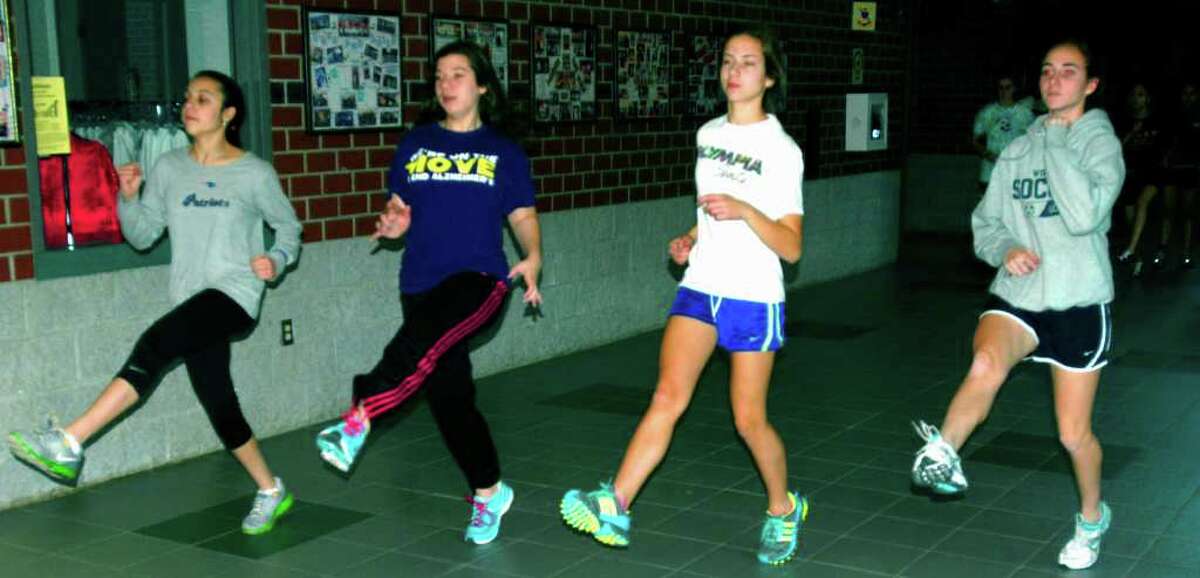 SPECTRUM/Warming up for a pre-season practice are, from left to right, Rebecca Andrade, Samantha Courtney, Kaitlyn Robinson and Anna Fossi of New Milford High School girls' indoor track, December 2011