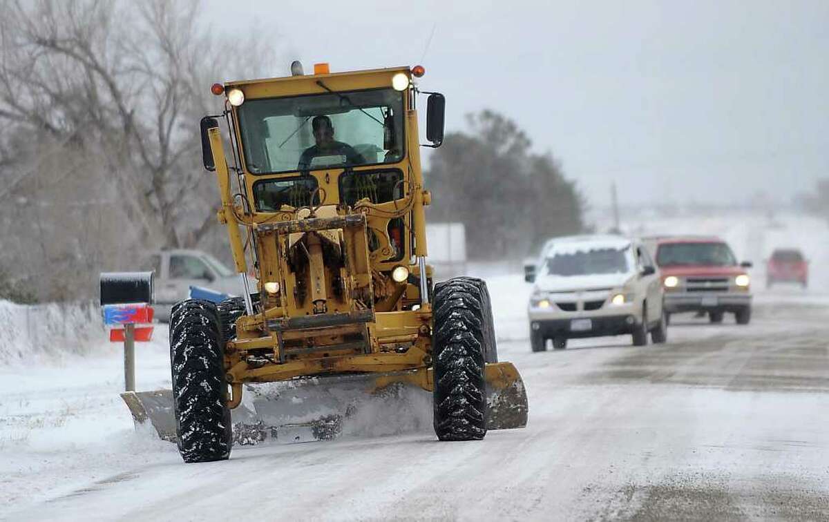 A Potter County road grader works to clear parts of Indian Hills Road Tuesday, Dec. 20, 2011 in Amarillo, Texas. Travelers in the Texas Panhandle were urged to stay off ice-packed roads Tuesday after up to 10 inches of snow covered parts of the region. Several major thoroughfares were closed after the storm clipped the far northwest part of the state the day before the official start of winter.