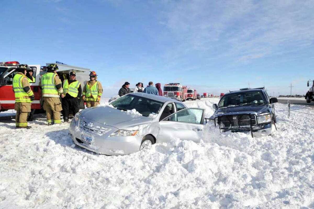 Emergency responders assists victims of a multiple-vehicle accident on westbound Interstate 40 about 15 miles west of Amarillo, Texas Tuesday, Dec. 20, 2011. Travelers in the Texas Panhandle were urged to stay off ice-packed roads Tuesday after up to 10 inches of snow covered parts of the region. (AP Photo/The Amarillo Globe News, Michael Schumacher)