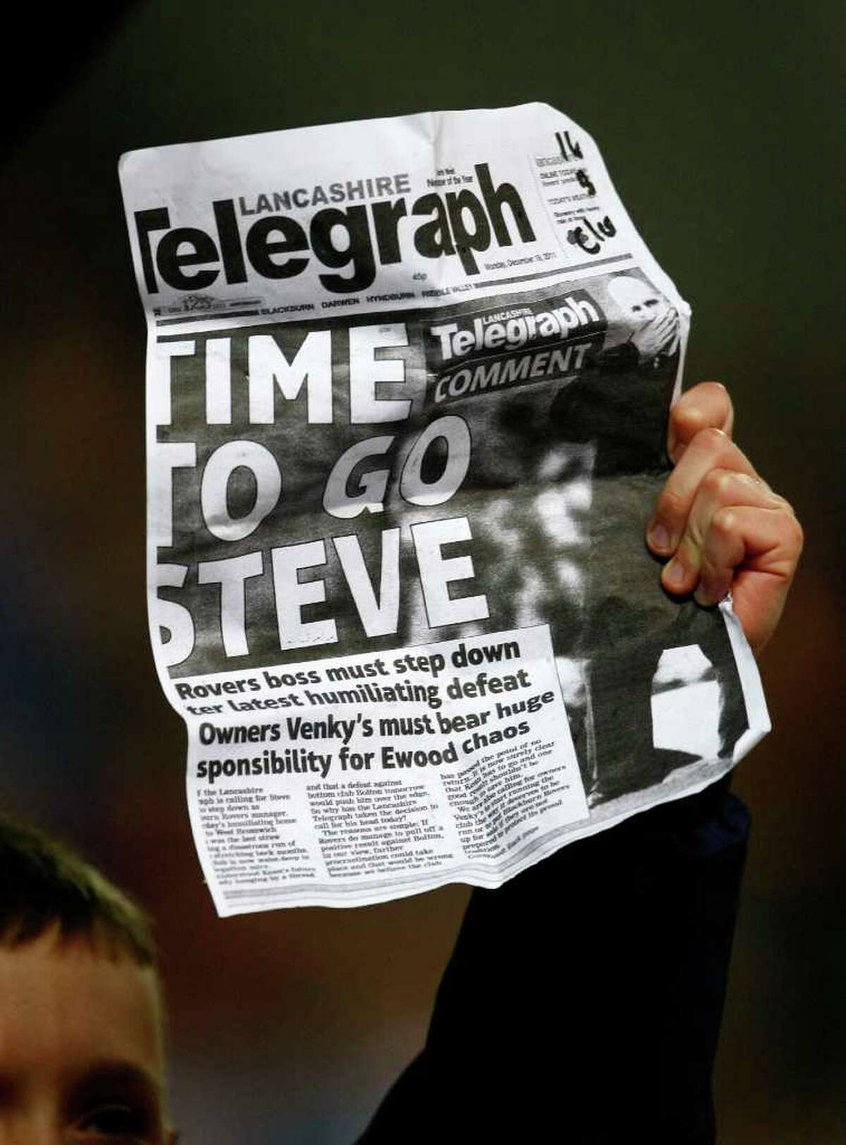 A Blackburn fan holds up a newspaper clipping during the English Premier League soccer match against Bolton at Ewood Park, Blackburn, England, Tuesday Dec. 20, 2011. (AP Photo/Tim Hales)