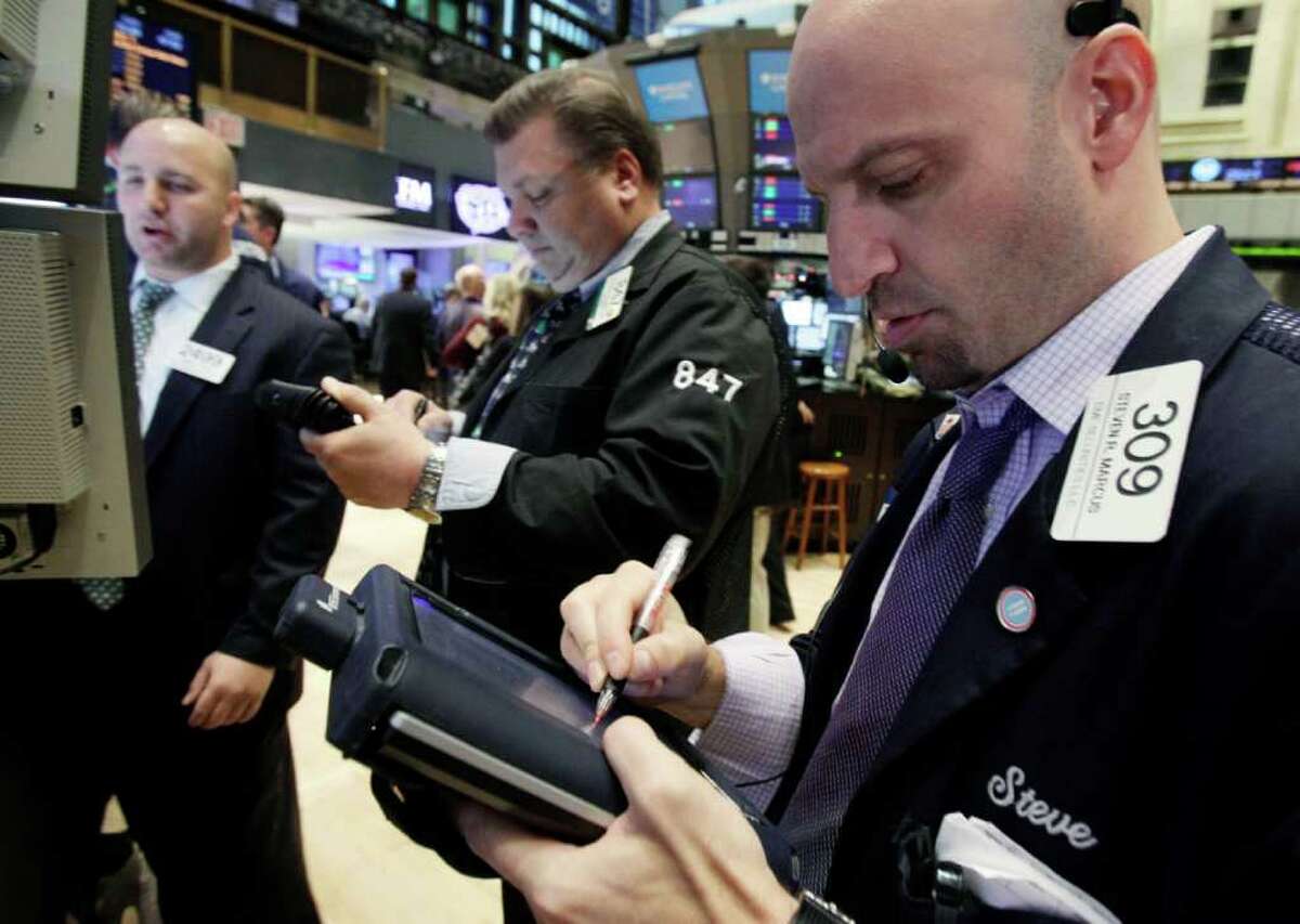 In this Dec. 20, 2011 photo, Steven Marcus, right, works with fellow traders on the floor of the New York Stock Exchange. European stock markets extended gains Wednesday, Dec. 21, on a wave of pre-holiday optimism after the European Central Bank loaned a record amount to the continent's banks in an effort to bolster Europe's stressed financial system. (AP Photo/Richard Drew)