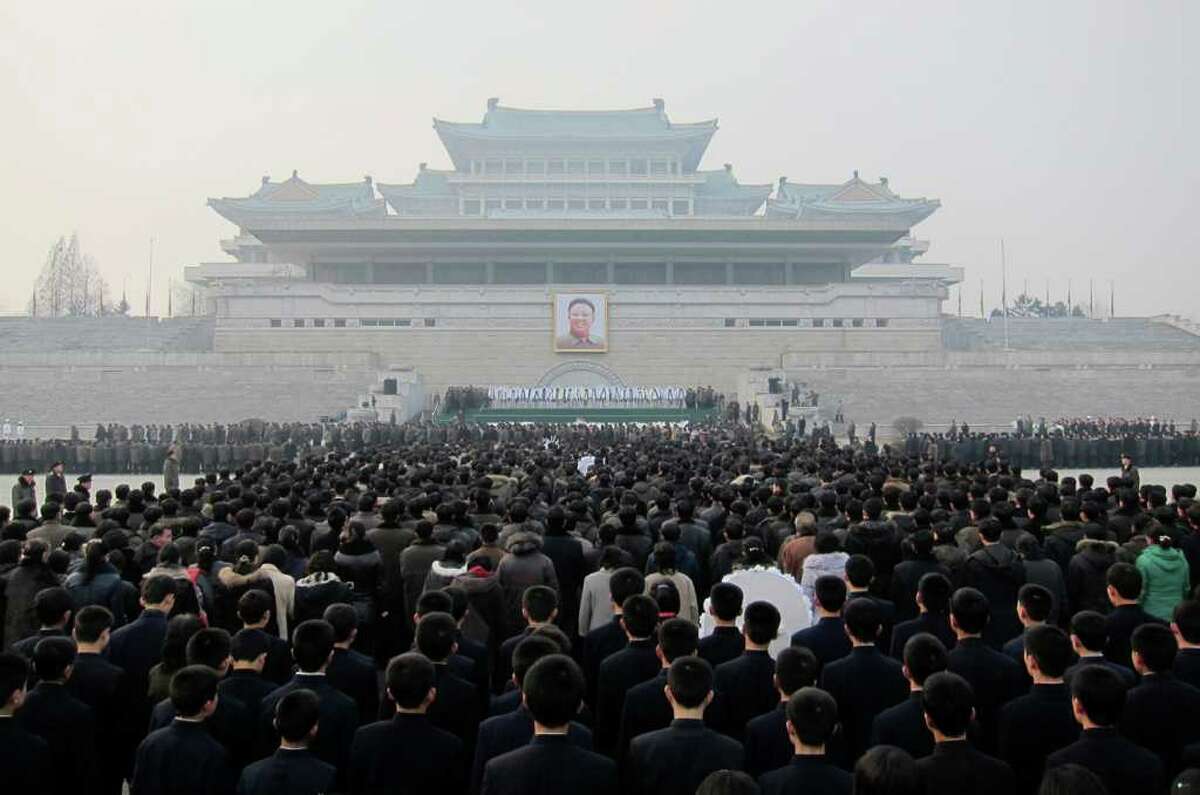 ASSOCIATED PRESS/APTN MASS MOURNING: Throngs of North Koreans queue up Wednesday to mourn the death of Kim Jong Il in front of a portrait of him put up in Kim Il Sung Square in Pyongyang.