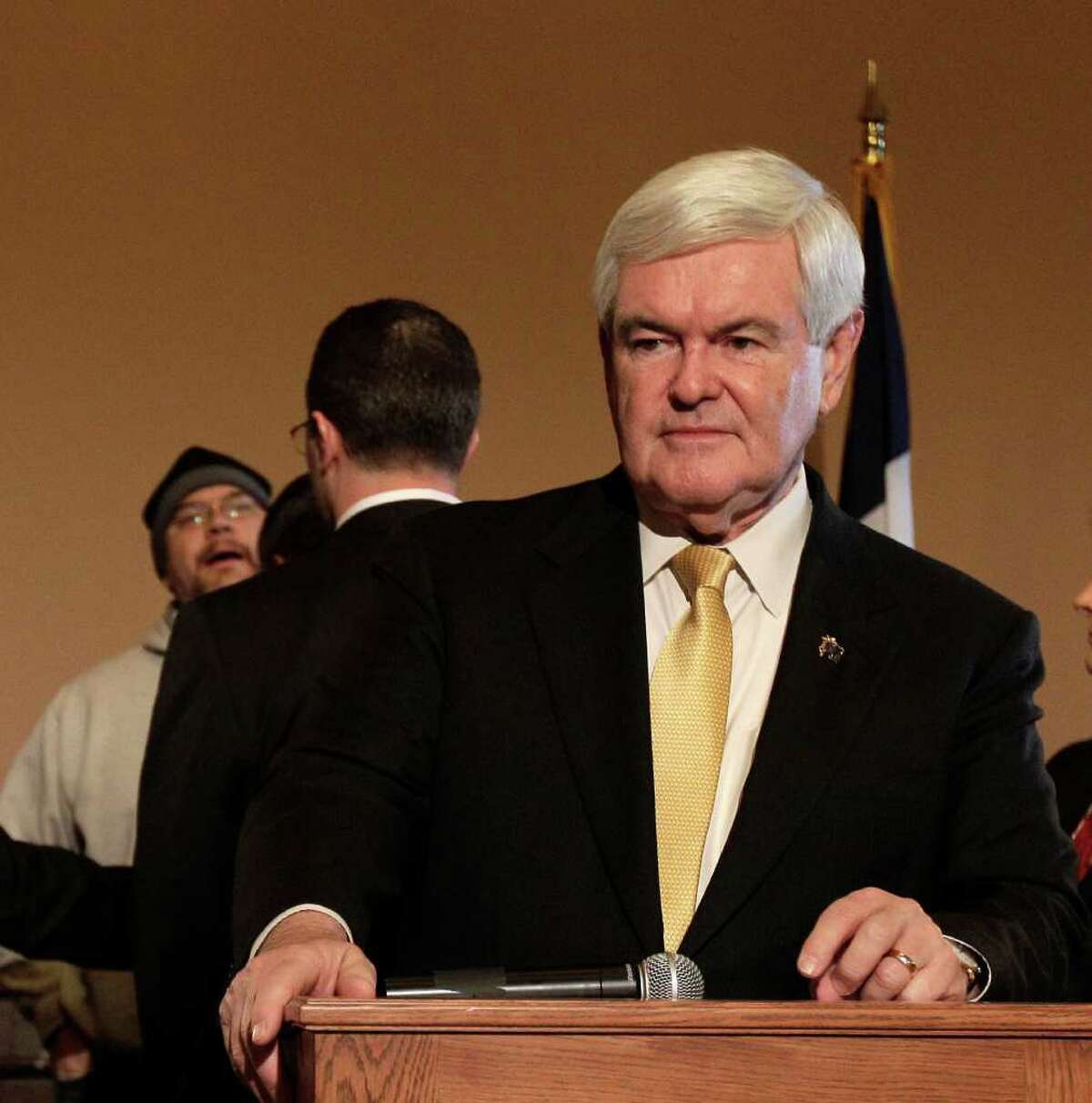 Republican presidential candidate, former House Speaker Newt Gingrich, pauses as an unidentified protester is confronted by security during a news conference at the Iowa State Capitol in Des Moines, Iowa, Wednesday, Dec. 21, 2011. (AP Photo/Charlie Riedel)