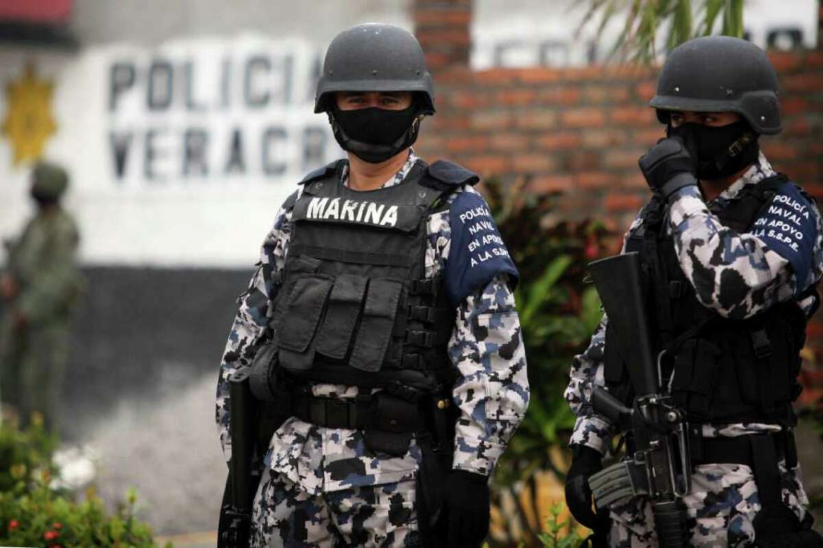Masked Mexican navy marines stand outside of a police station after the entire police force was disbanded in the Gulf port city of Veracruz, Mexico Wednesday Dec. 21, 2011. The Veracruz state government said the decision is part of an effort to root out police corruption and start from zero in the state's largest city. The navy will be in charge of patrolling the city for the time being. (AP Photo/Felix Marquez)