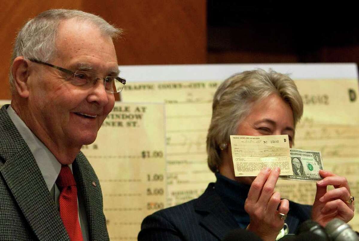Dale Crawford, left, and Mayor Annise Parker, right, laugh as she holds a 58-year-old parking ticket issued to Crawford and $1.00 to pay it during a press conference at City Hall Wednesday, Dec. 21, 2011, in Houston. Crawford received the ticket on Feb. 3, 1953, the day he was inducted into the U.S. Army when he left his 1946 Nash at the induction station where his father arrived late to pick it up. Crawford wrote to the city, "the ticket is $1.00, a small, almost unnoticeable amount. It is a debt and I want to pay what I owe." (Cody Duty / Houston Chronicle)