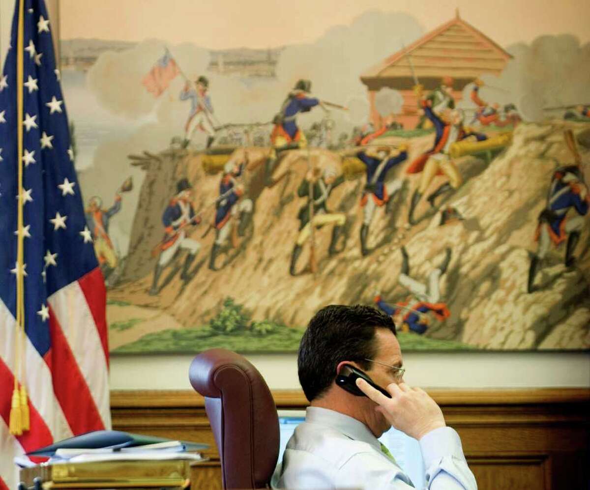 Gov. Dan Malloy sits beneath a panel of historic Zuber wallpaper, depicting a battle from the American Revolution. Malloy spotted the prints in an office in the capitol and asked that they be moved to his office. This day, Thursday April 15, 2011, marked the governor's 100th day in office.
