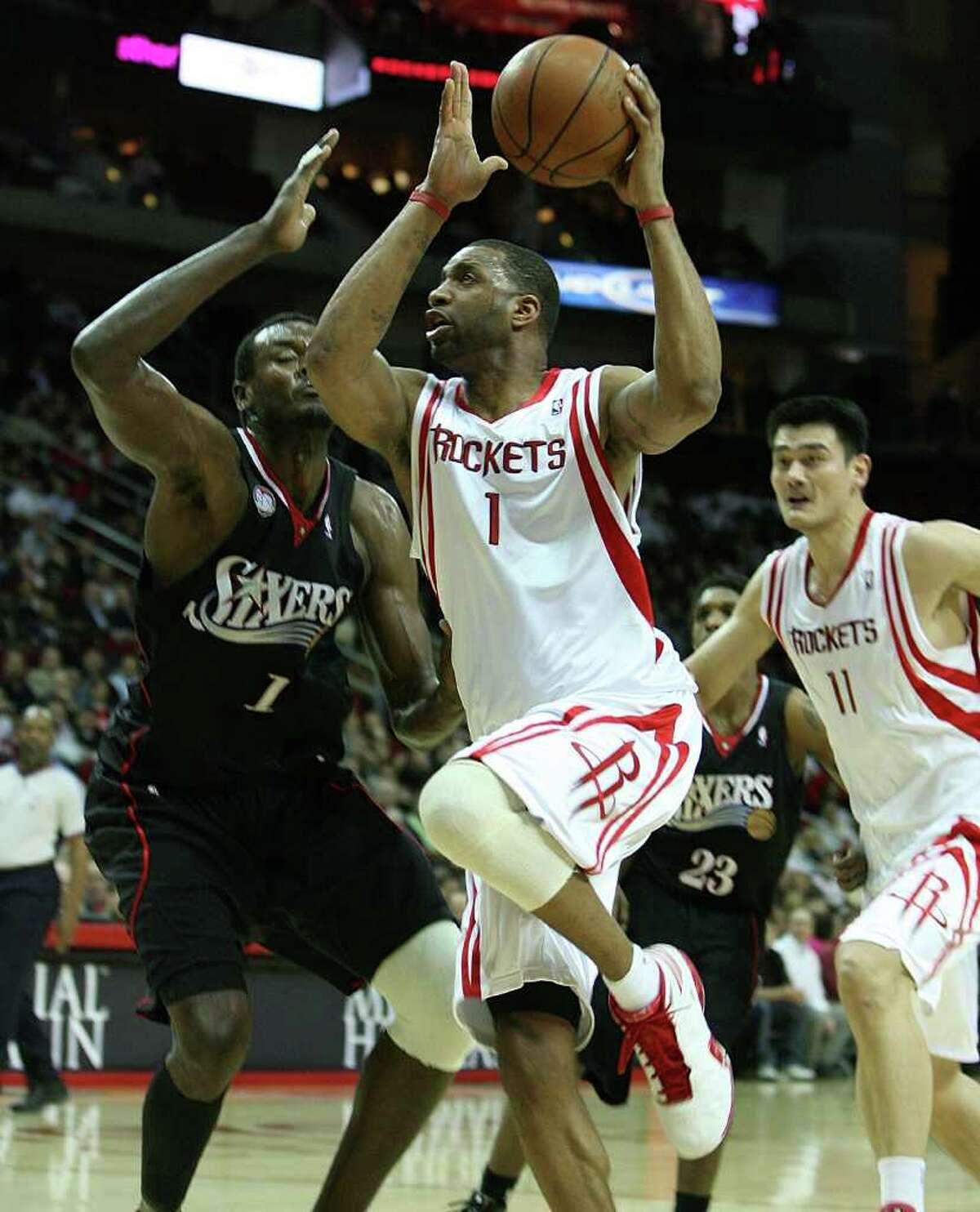 (l-r) Philadelphia 76ers (1) Samuel Dalembert attempts to defend Houston Rockets forward (1) Tracy McGrady as he drives to the basket during the first half of the Houston Rockets match up with the Philadelphia 76ers at the Toyota Center Wednesday, Jan. 28, 2009, in Houston. (Billy Smith II / Chronicle )