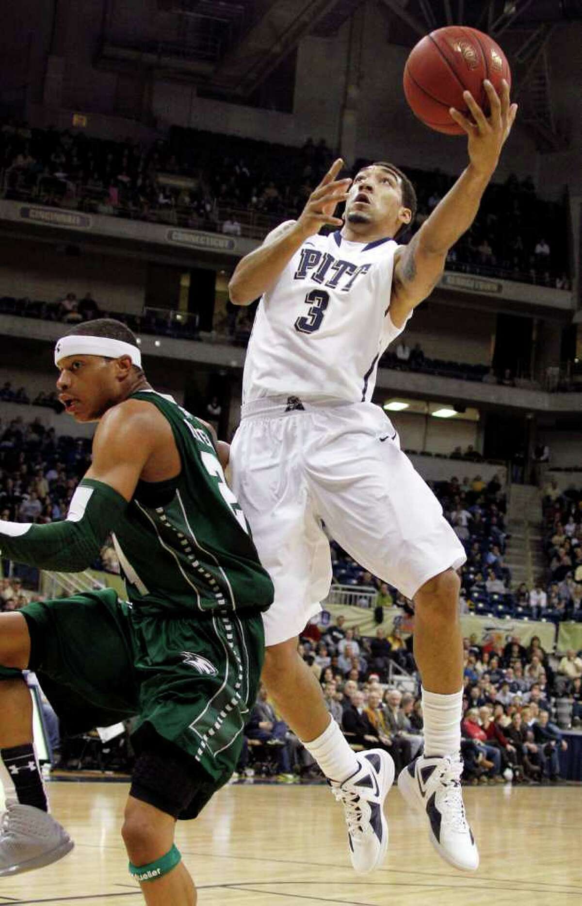 Pittsburgh's Cameron Wright (3) goes in for a layup behind Wagner's Latif Rivers in the first half of the NCAA college basketball game on Friday, Dec. 23, 2011, in Pittsburgh. (AP Photo/Keith Srakocic)