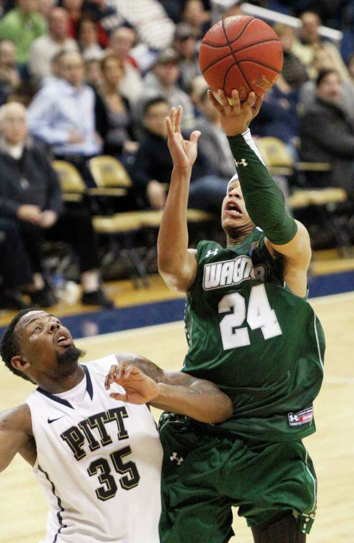 Wagner's Latif Rivers (24) goes over Pittsburgh's Nasir Robinson (35) to score in the second half of the NCAA college basketball game on Friday, Dec. 23, 2011, in Pittsburgh. Wagner upset Pittsburgh 59-54. (AP Photo/Keith Srakocic)