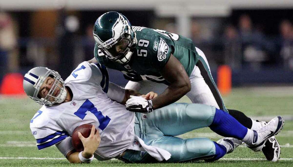 Dallas Cowboys' Stephen McGee slides under Philadelphia Eagles' Brian Rolle on a play during second half action Saturday Dec. 24, 2011 at Cowboys Stadium in Arlington, TX. The Eagles won 20-7. PHOTO BY EDWARD A. ORNELAS/eaornelas@express-news.net)