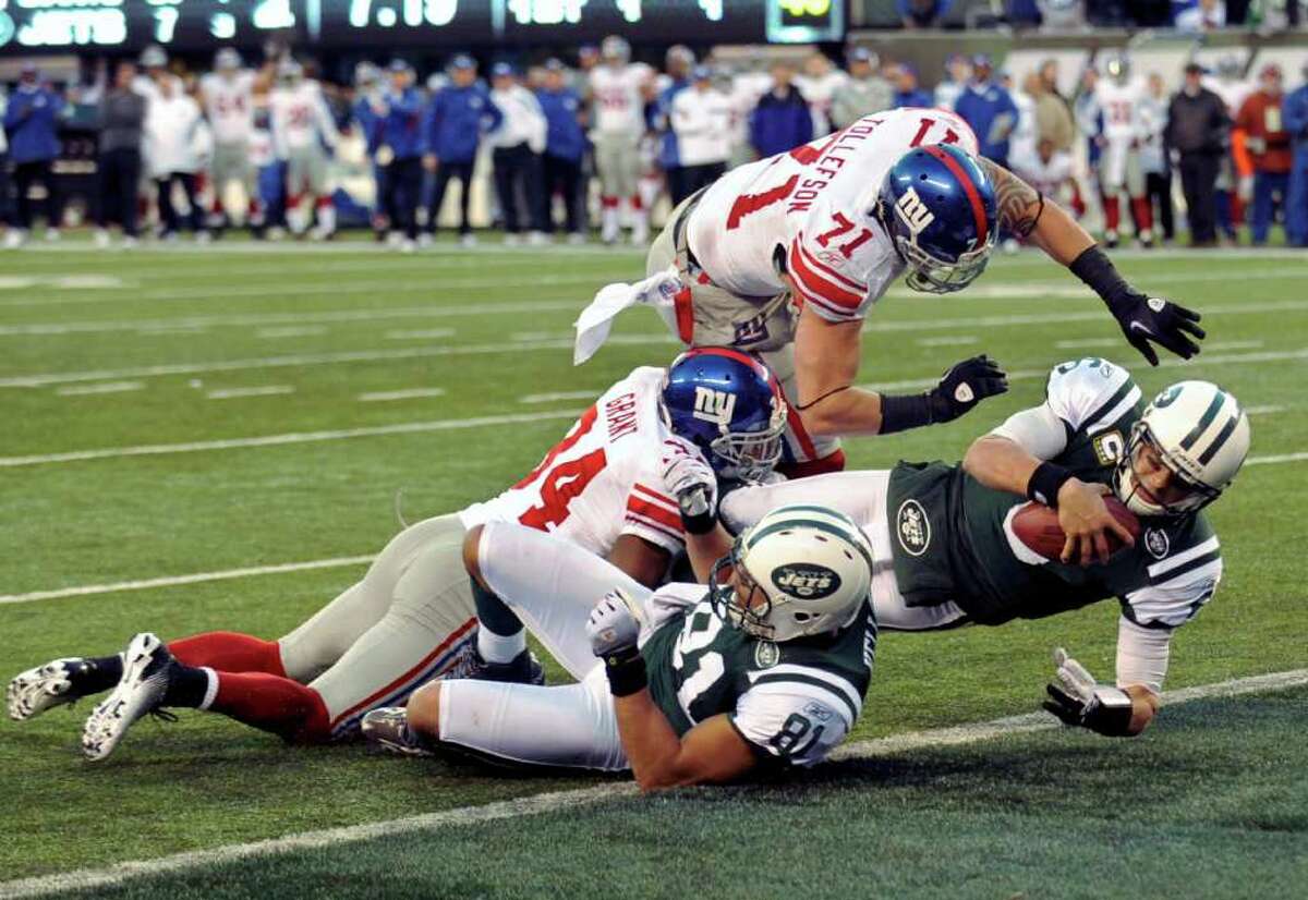 New York Jets' Mark Sanchez, right, scores a touchdown during the fourth quarter of an NFL football game against the New York Giants, Saturday, Dec. 24, 2011, in East Rutherford, N.J. (AP Photo/Bill Kostroun)