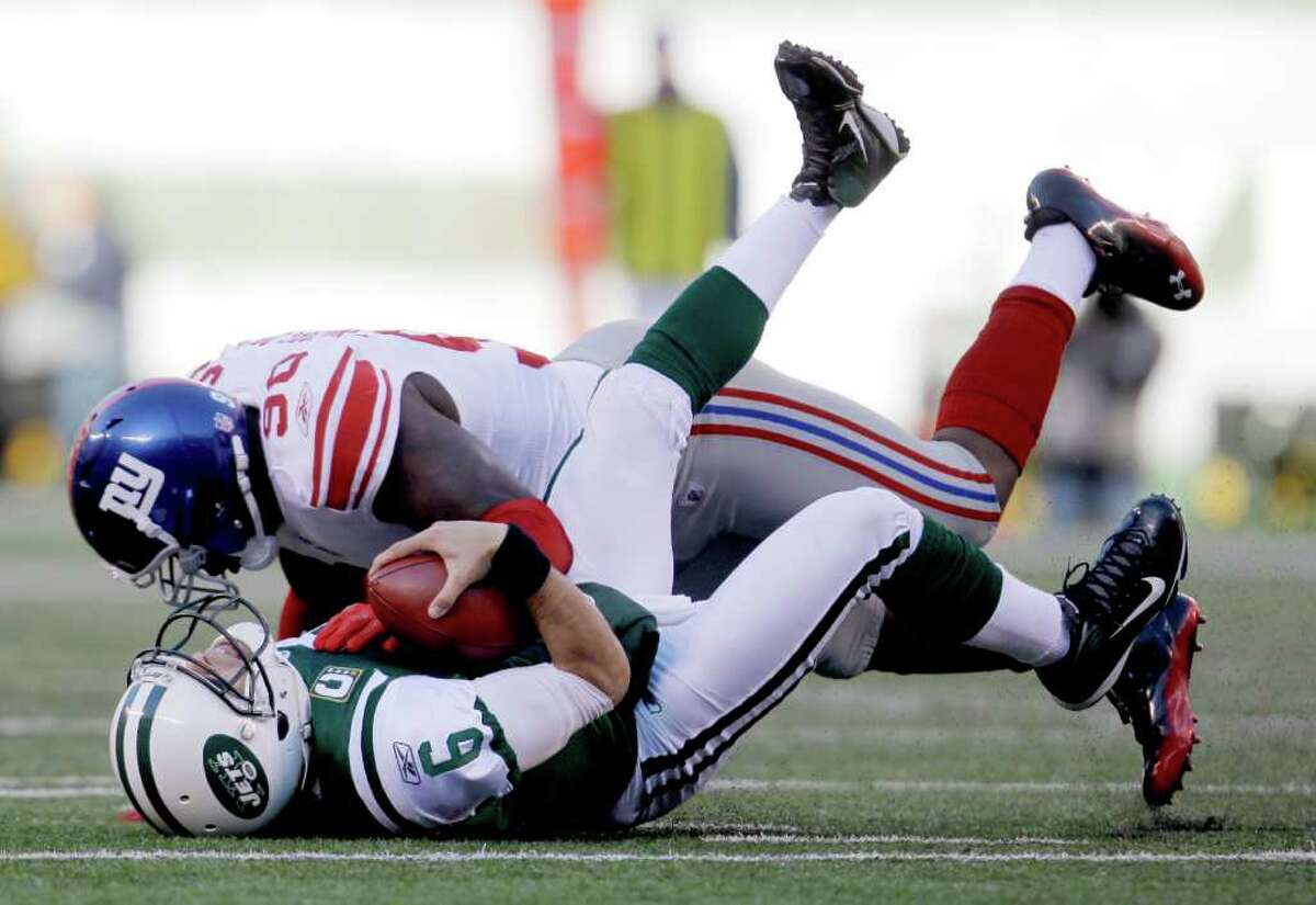 JULIO CORTEZ: ASSOCIATED PRESS DOWN GOES SANCHEZ: The New York Giants' Jason Pierre-Paul sacks the New York Jets' Mark Sanchez in the second quarter of their game in East Rutherford, N.J.