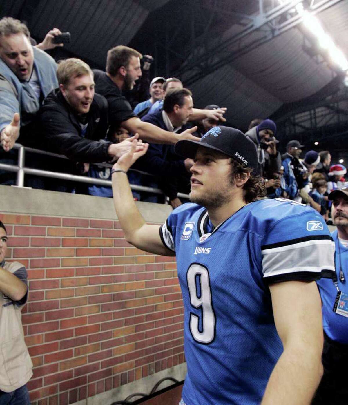 Detroit Lions quarterback Matthew Stafford (9) celebrates with fans after the Lions defeated the San Diego Chargers 38-10 in an NFL football game to clinch a playoff spot on Saturday, Dec. 24, 2011, in Detroit. (AP Photo/Duane Burleson)