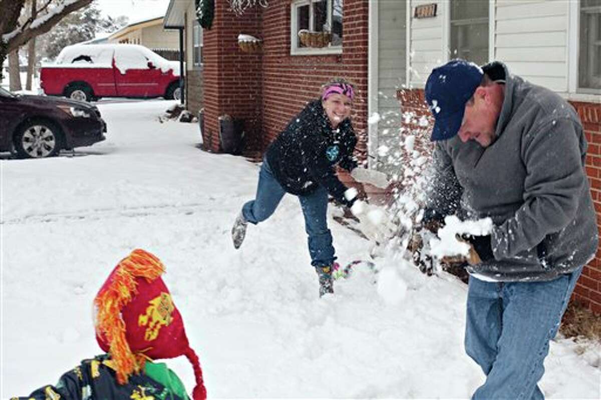 Nichole Mathis hits her husband, Mark, with a snowball as their son Jack, 4, watches during a family snowball fight Saturday, Dec. 24, 2011 outside of their home in Odessa, Texas. The National Weather service in Midland reported 3.8 inches at Midland International Airport as of 2:30 p.m. Saturday. (AP Photo/Odessa American, Albert Cesare)