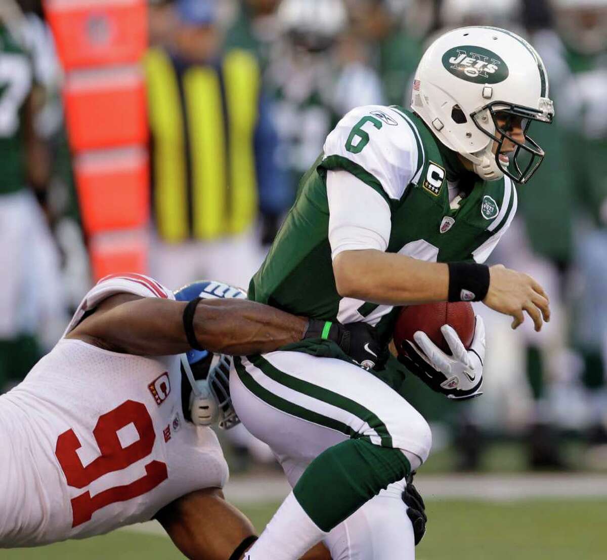 New York Jets quarterback Mark Sanchez, right, is sacked by New York Giants' Justin Tuck (91) during the third quarter of an NFL football game Saturday, Dec. 24, 2011, in East Rutherford, N.J. (AP Photo/Julio Cortez)