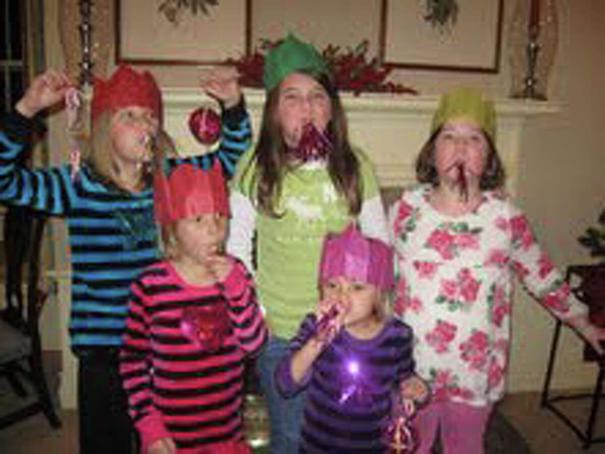 Celebrating with the spoils from their Christmas Crackers, including noisemakers, paper hats, treats and a motto from George Washington are, front row, Hadley and Delaney Bennhoff; back row, Mallory Bennhoff, Gwenan Walker and Anna Reed.