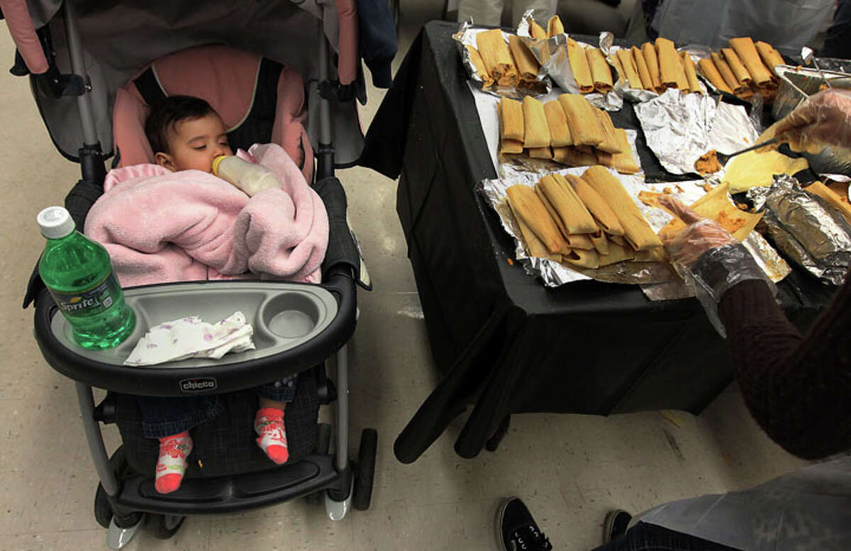 Six-month-old Azmeray Nadeen Serda naps while her mother, Samantha Ann Alvarez, volunteers in making tamales at Lanier High School for a record-setting tamalada on Wednesday, Dec. 7, 2011. Organizers said about 1,100 students and 200 neighborhood volunteers gathered at the school to make tamales and to attempt to set a record for the most made by weight. In the end, they achieved the goal of 17,232 tamales weighing in at 2,420.9 pounds. The achievement will now be sent off to Guiness Book of World Records to be certified.