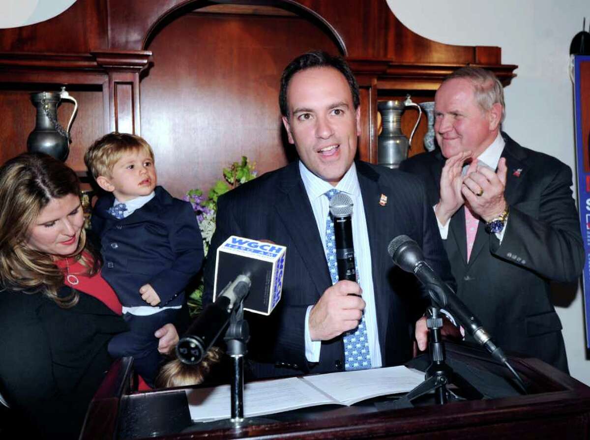 Greenwich First Selectman Peter Tesei, center, and Selectman David Theis, right, celebrate their election-night victory at the Milbrook Club, Greenwich Nov. 8, 2011. At left is Tesei's wife, Jill, who is holding their son, James, 2.