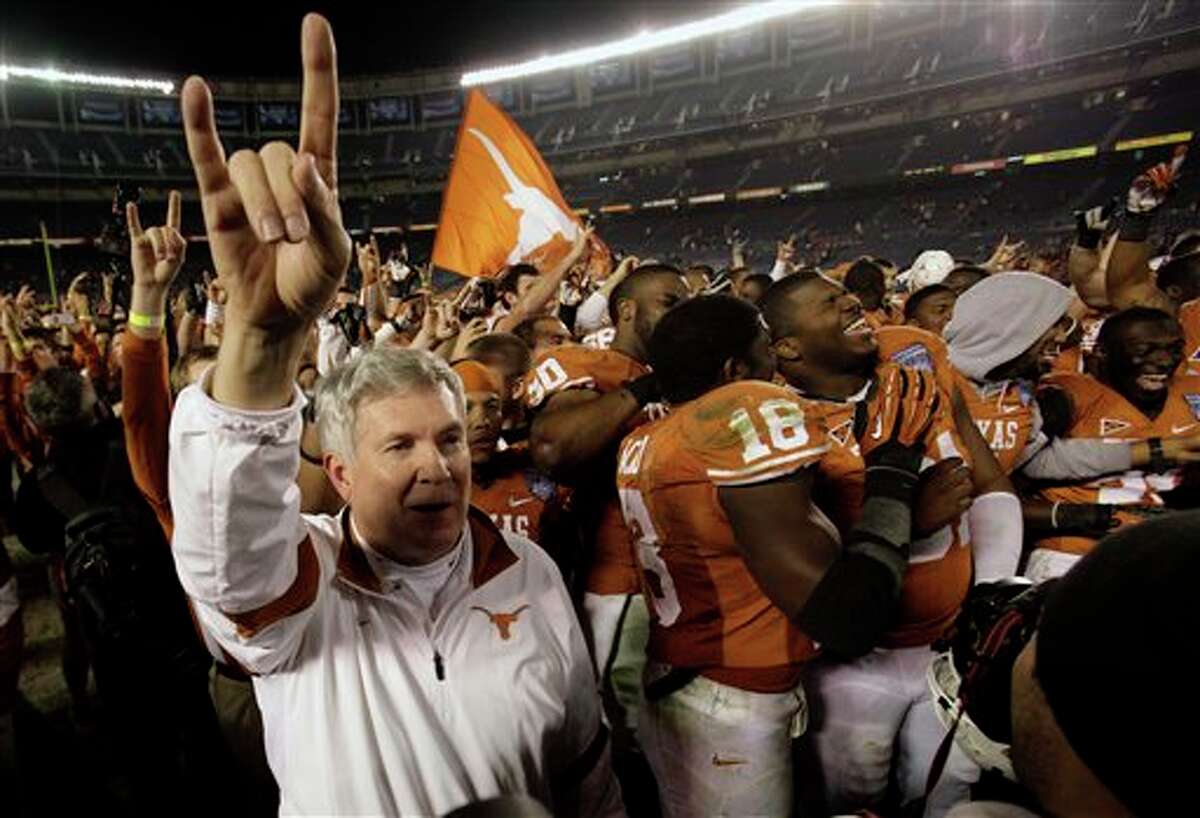 Texas head coach Mack Brown, left, celebrates with his team after beating California 21-10 to win the Holiday Bowl NCAA college football game Wednesday, Dec. 28, 2011, in San Diego. (AP Photo/Gregory Bull)