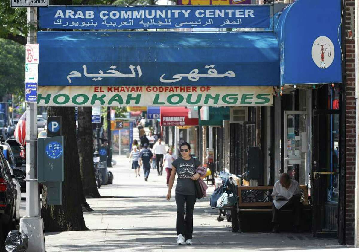 FILE - In this Sept. 2, 2011 file photo, people walk past immigrant Arab businesses on Steinway Street in the Astoria neighborhood of the Queens borough of New York. Several Muslim leaders have declined invitations to the mayor's annual year-end interfaith breakfast on Friday, Dec. 30, 2011, saying they're upset at police department efforts to infiltrate mosques and spy on Muslim neighborhoods. The imams and activists said in a letter to Mayor Michael Bloomberg that they're disturbed at his response to a series of stories by The Associated Press detailing New York Police Department intelligence-gathering programs that monitored Muslim groups, businesses and houses of worship. (AP Photo/Charles Dharapak, File)