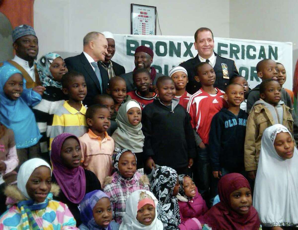 In this photo provided by the New York Police Department, New York Police Commissioner Raymond Kelly, top, third from left, and Bronx Borough Patrol Chief Carlos M. Gomez, top right, join Imam Sefou Mohamed, far left, and Imam Adbullah Bajaha, smiling, center, at Masjid Salam mosque in the Bronx borough of New York, with members of the police department's United Youth Soccer League. Several Muslim leaders have declined invitations to the mayor's annual year-end interfaith breakfast on Friday, Dec. 30, 2011, saying they're upset at police department efforts to infiltrate mosques and spy on Muslim neighborhoods. The imams and activists said in a letter to Mayor Michael Bloomberg that they're disturbed at his response to a series of stories by the Associated Press detailing New York Police Department intelligence-gathering programs that monitored Muslim groups, businesses and houses of worship. (AP Photo/New York Police Department)