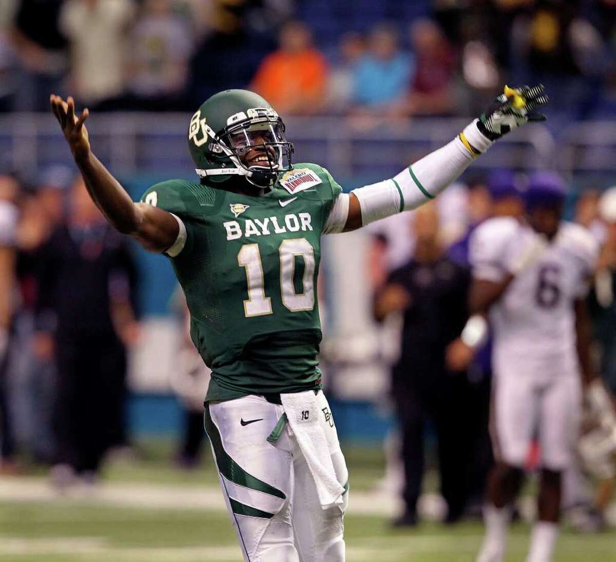 Robert Griffin III raise his arms in celebration as he runs away from players at the end of the game as Baylor beats Washington 67-56 in the Valero Alamo Bowl 2011 at the Alamodome in San Antonio, Texas on December 29, 2011 Tom Reel/Staff