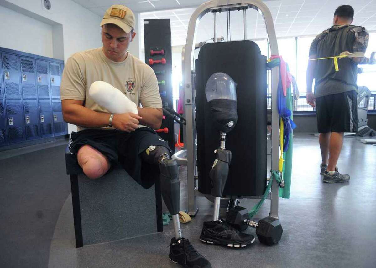 BILLY CALZADA : SAN ANTONIO EXPRESS-NEWS DRIVEN: Army Capt. William Lyles, who was wounded by an improvised explosive device in Afghanistan in 2010, adjusts the padding for one of his prosthetic legs in November at the Center for the Intrepid at Brooke Army Medical Center.