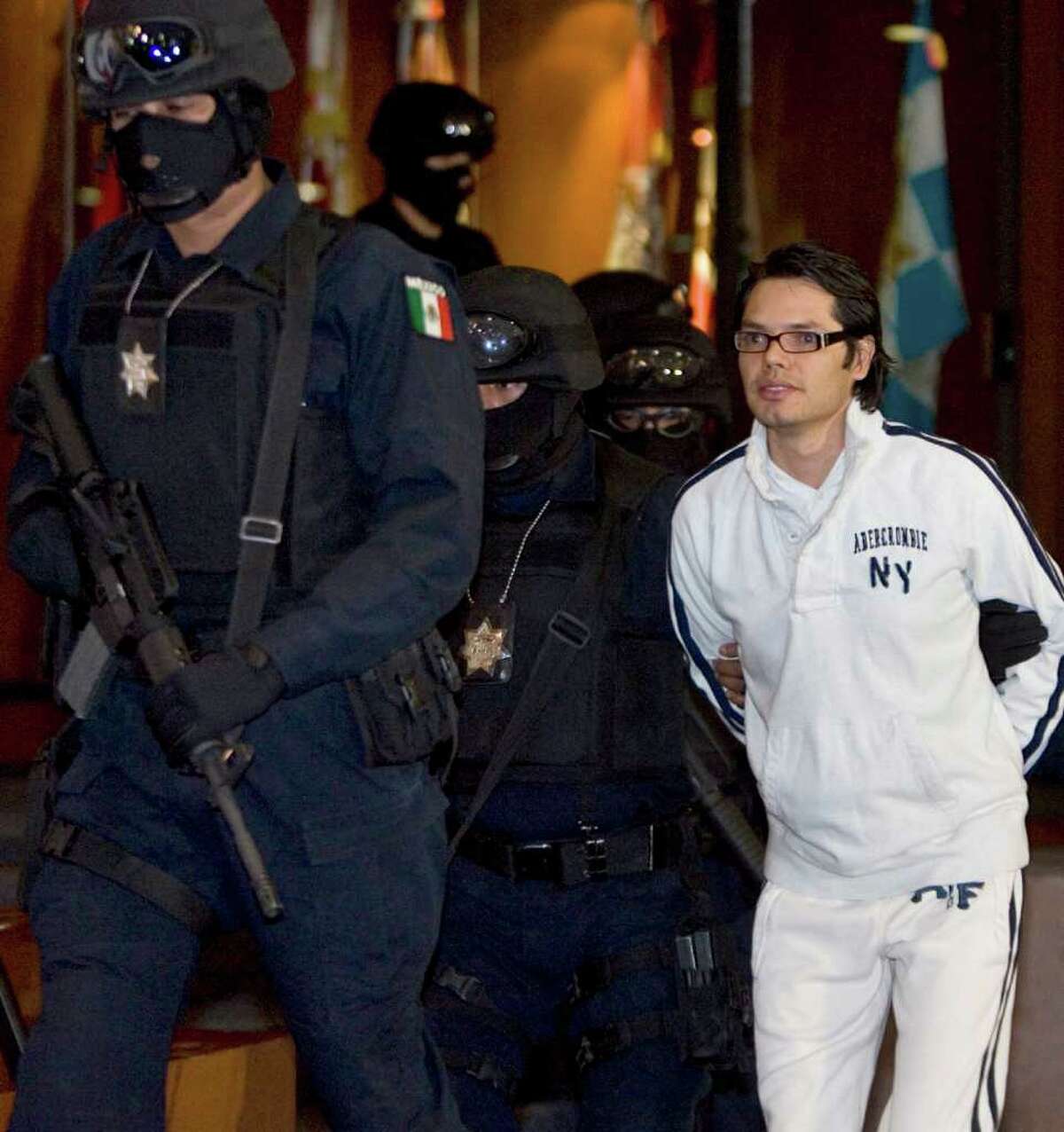 Mexican federal agents escort alleged Mexican drug trafficker Vicente Carrillo Leyva, right, during his presentation to the media in Mexico City in 2009.