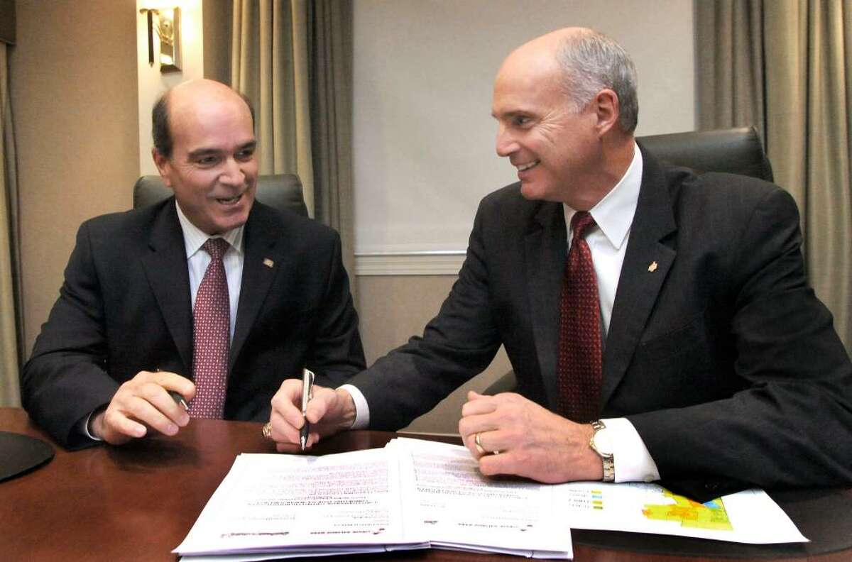 Joseph Greco, Pres. & CEO, First Litchfield Financial Corp., left, and John Kline, Pres & CEO Union Savings, signing documentation for the purposed merger of the two banks in the Boardroom of the Union Savings Bank in Danbury, on Monday, Oct.26,2009.