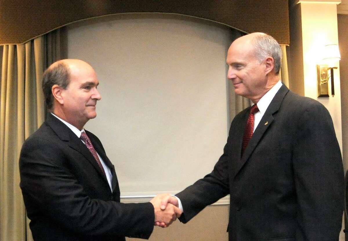 Joseph Greco, Pres. & CEO, First Litchfield Financial Corp., left, and John Kline, Pres. & CEO, Union Savings Bank, shake hands during a meeting to announce a proposed merger between the two banks in the Boardroom of the Union Savings Bank in Danbury on Monday, Oct. 26,2009.