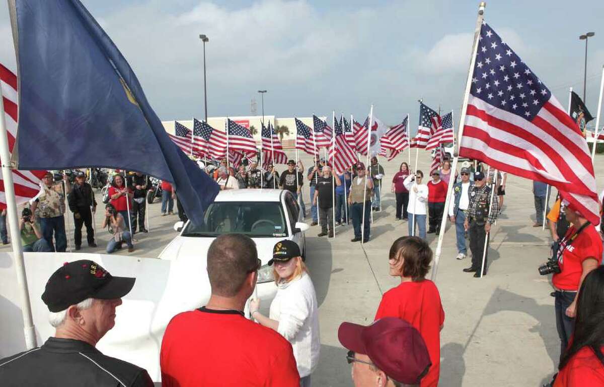 Kevin Gillane (bottom, second from left) is surrounded by members of the Patriot Guard Riders of Southest Texas as they welcomed him home during a surprise trip to the Target parking lot in Galveston on December 31, 2011. Gillane returned home from his first tour of service in the U. S. Navy Seebees in Afghanistan. (Alan Warren, For the Chronicle)