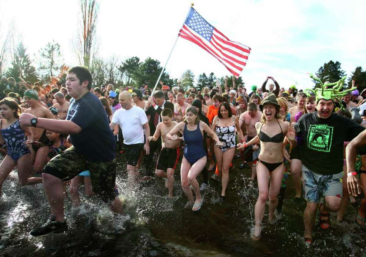 Participants brave the 49-degree Lake Washington water during the annual Polar Bear Plunge at Matthews Beach in Seattle.