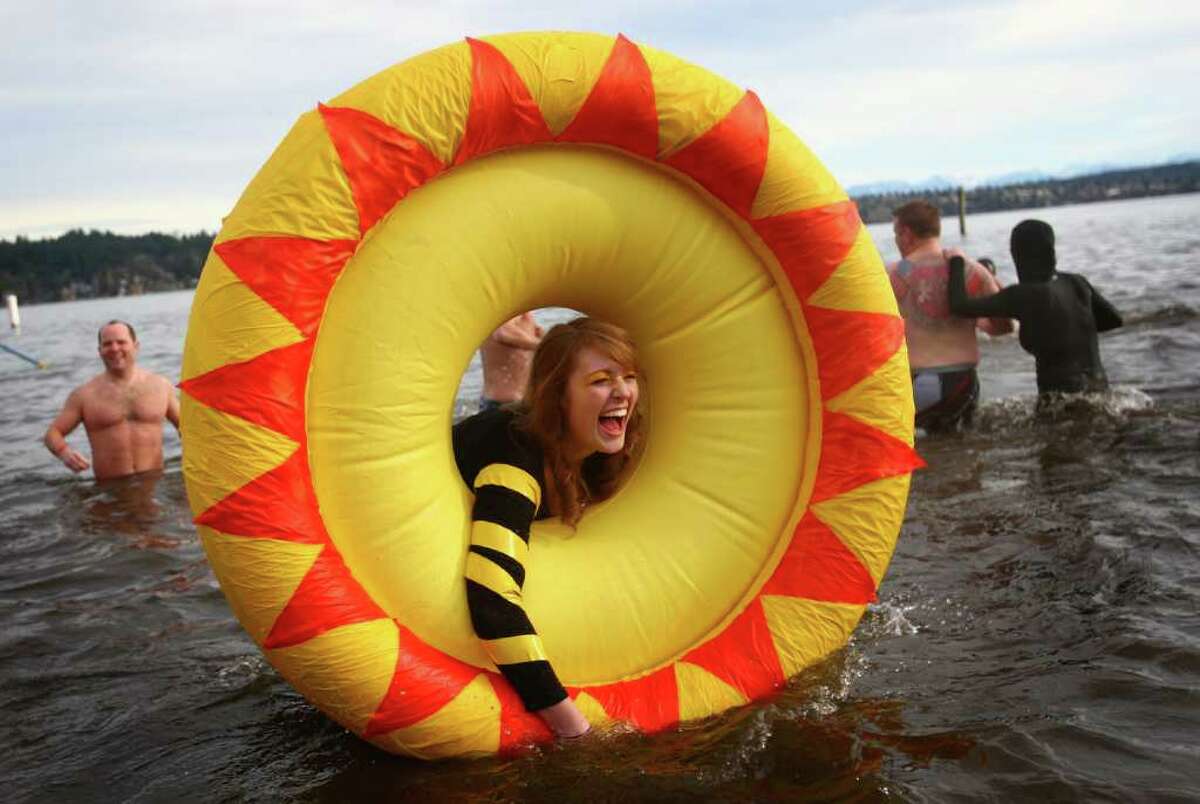 Laura D'Asaro holds onto an inflatable sun as she braves the 49-degree Lake Washington water during the annual Polar Bear Plunge at Matthews Beach in Seattle on Sunday.