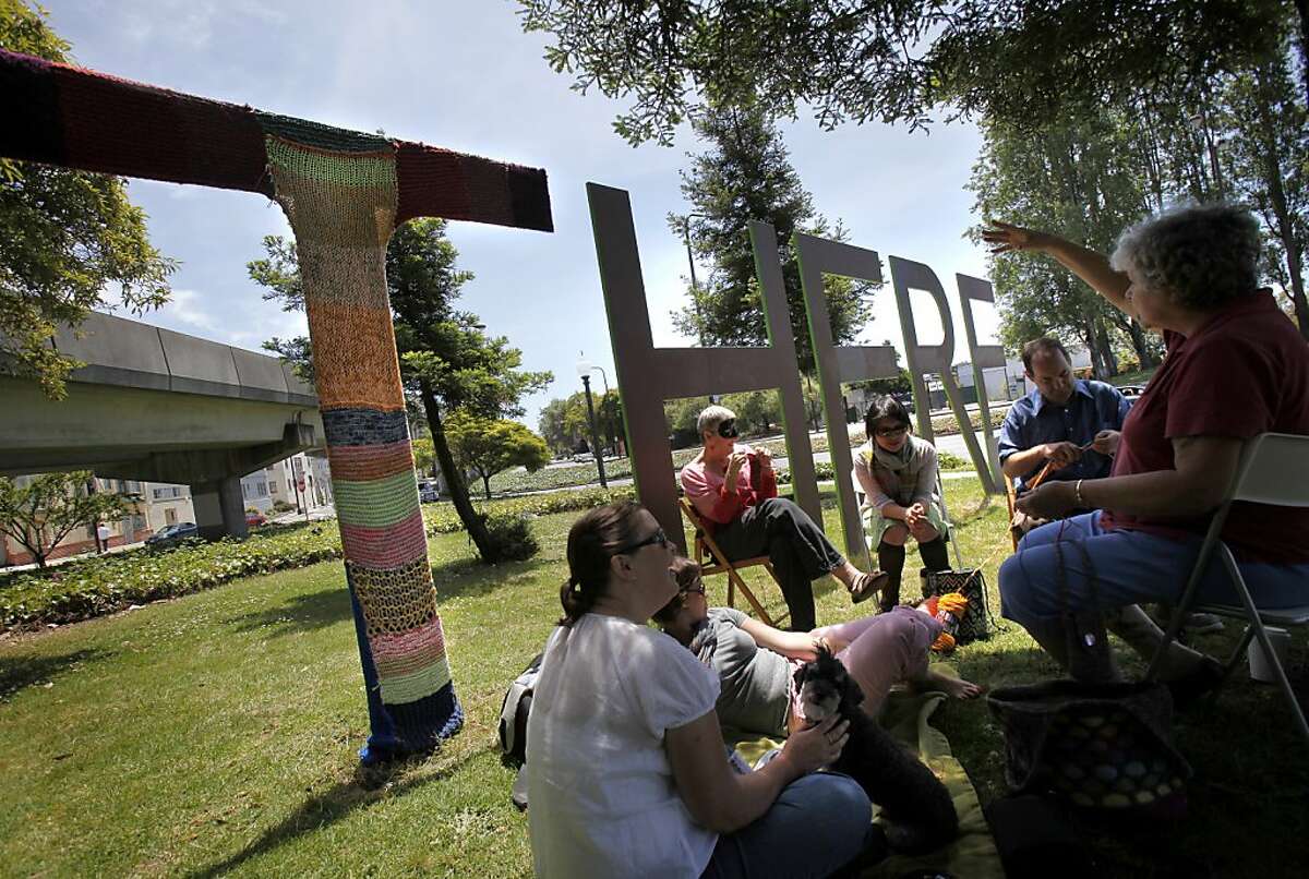 A group of knitters from Oakland have covered the "T" of the "There/Here" sculpture between Berkeley and Oakland with yarn to protest the artwork, which they feel bashes Oakland.
