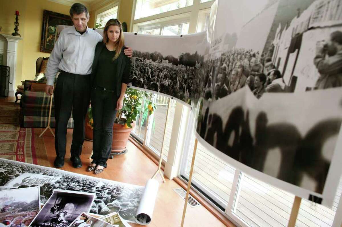 Greenwich resident and Harvard student Olenka Polak, right, and her father Jerzy, talk about the exhibition she helped organize at the university for her father's photographs documenting the Solidariy movement in Soviet Poland. They stand in their Riverside home with one of his panoramic photos Friday, Dec. 30, 2011.