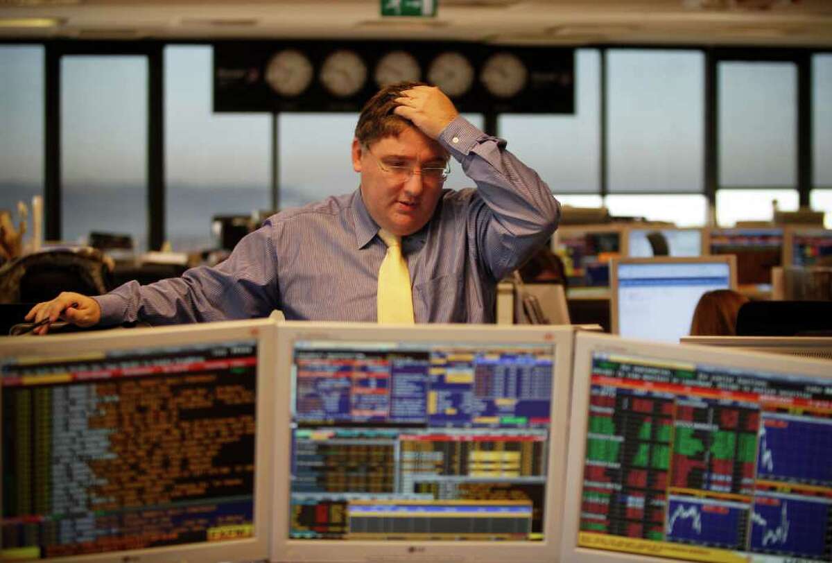 Portuguese broker Luis Gouveia reacts while talking with a colleague in a trading room of a Portuguese bank, Wednesday, Jan. 4, 2012, in Lisbon. Portugal has paid a markedly lower interest rate amidst a government austerity program aimed at winning back market confidence. Portugal's government debt agency said it sold 3-month Treasury bills after a similar auction last month. (AP Photo/ Francisco Seco)