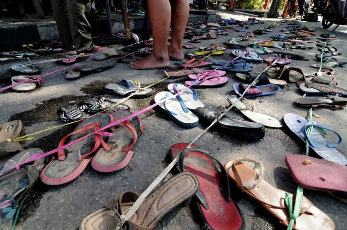 Shoes line the sidewalk outside a court in protest of a teen's prosecution for stealing an old pair of sandals.