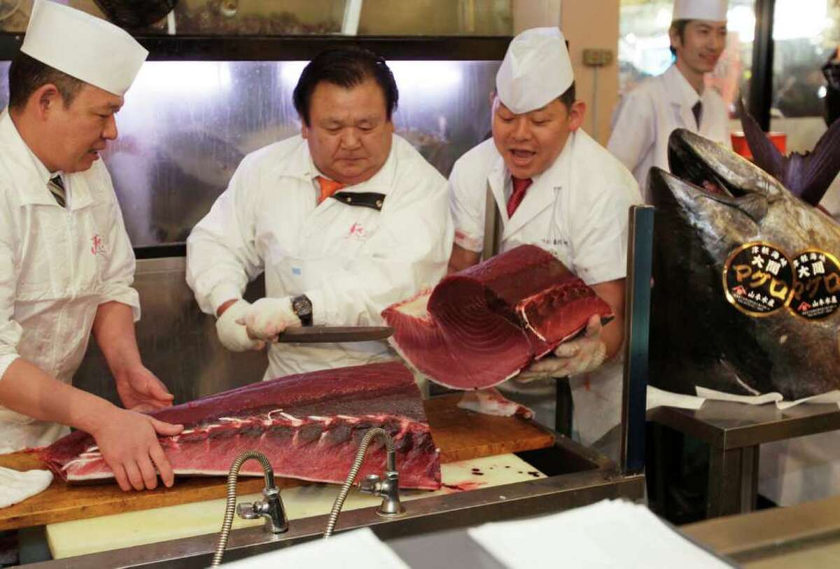 Kiyoshi Kimura, president of Kiyomura Co., center left, cuts a bluefin at his Sushi Zanmai restaurant near Tsukiji fish market in Tokyo Thursday, Jan. 5, 2012. The bluefin tuna caught off northeastern Japan fetched a record 56.49 million yen, or about $736,000, Thursday in the first auction of the year at the fish market. The tuna was caught off Oma in Aomori prefecture and just north of the coast that was battered by the March 11 tsunami. (AP Photo/Shizuo Kambayashi)