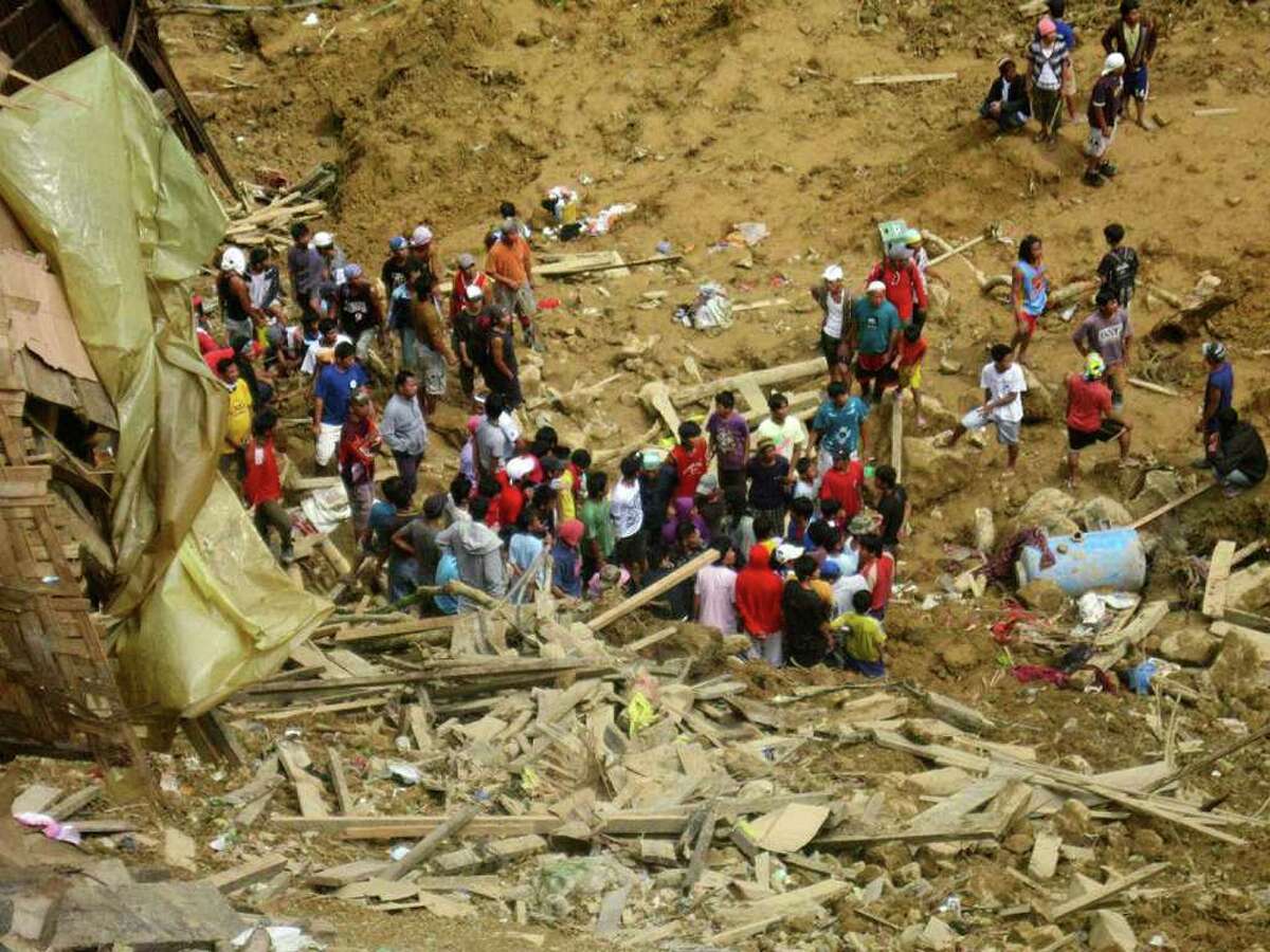 In this photo released by the Philippine Army, residents dig through the rubble following a landslide that occurred at the small-scale mining community of Pantukan, Compostela Valley in southern Philippines Thursday Jan. 5, 2012. The landslide tore through a small-scale gold mining site in the southern Philippines on Thursday, months after government officials warned miners that the mountain above them was guaranteed to crumble. (AP Photo/Philippine Army, Senior Police Officer 1 Roger Montejo) NO SALES, EDITORIAL USE ONLY